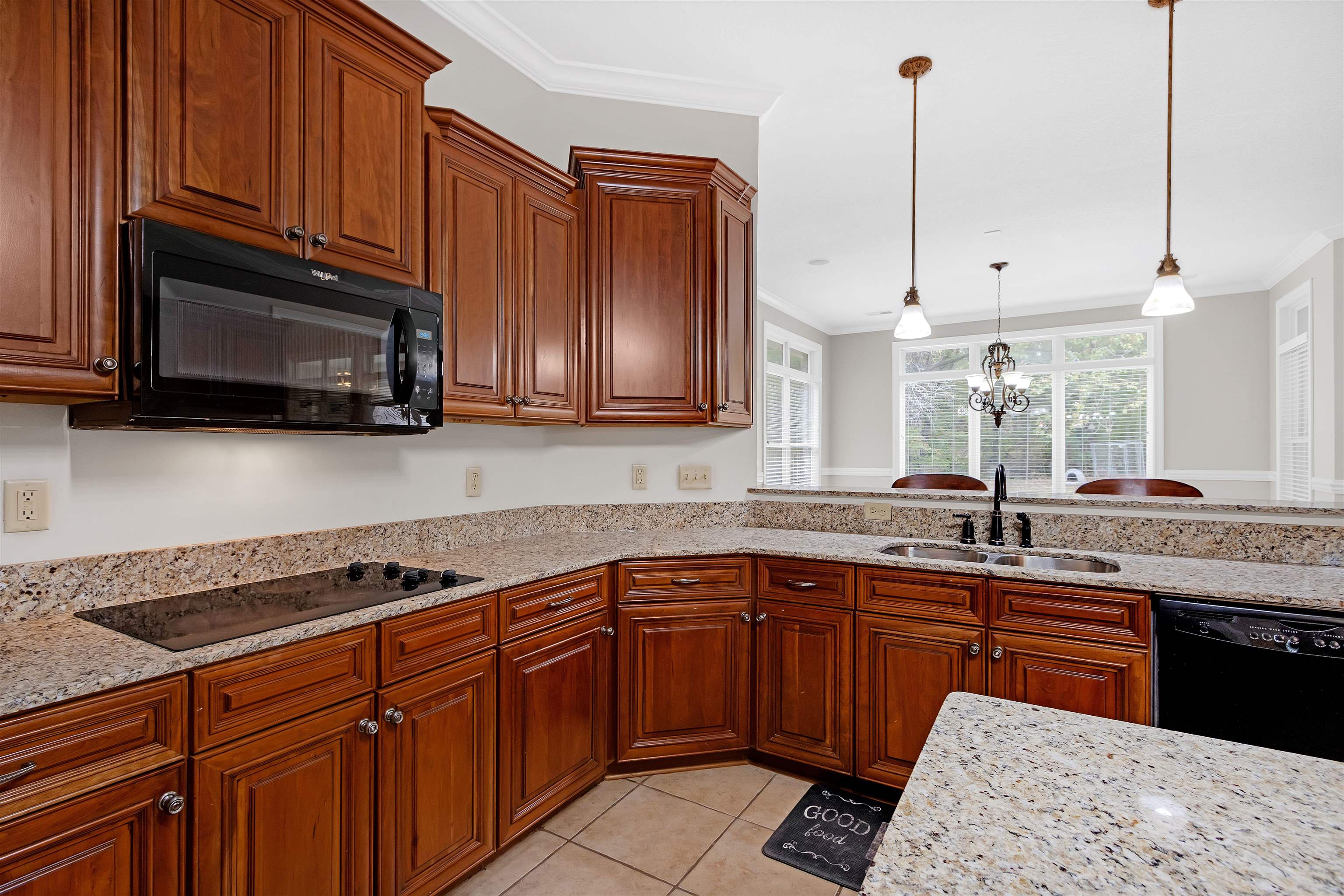 Kitchen with sink, black appliances, an inviting chandelier, crown molding, and pendant lighting