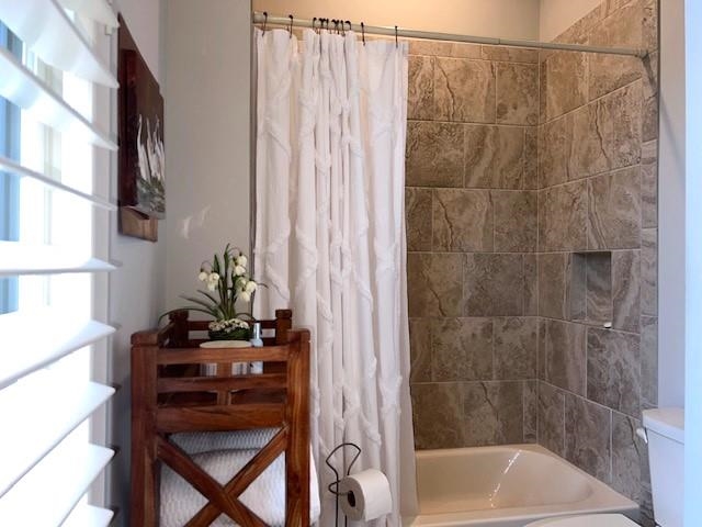 Bathroom featuring shower / bath combo with shower curtain and toilet