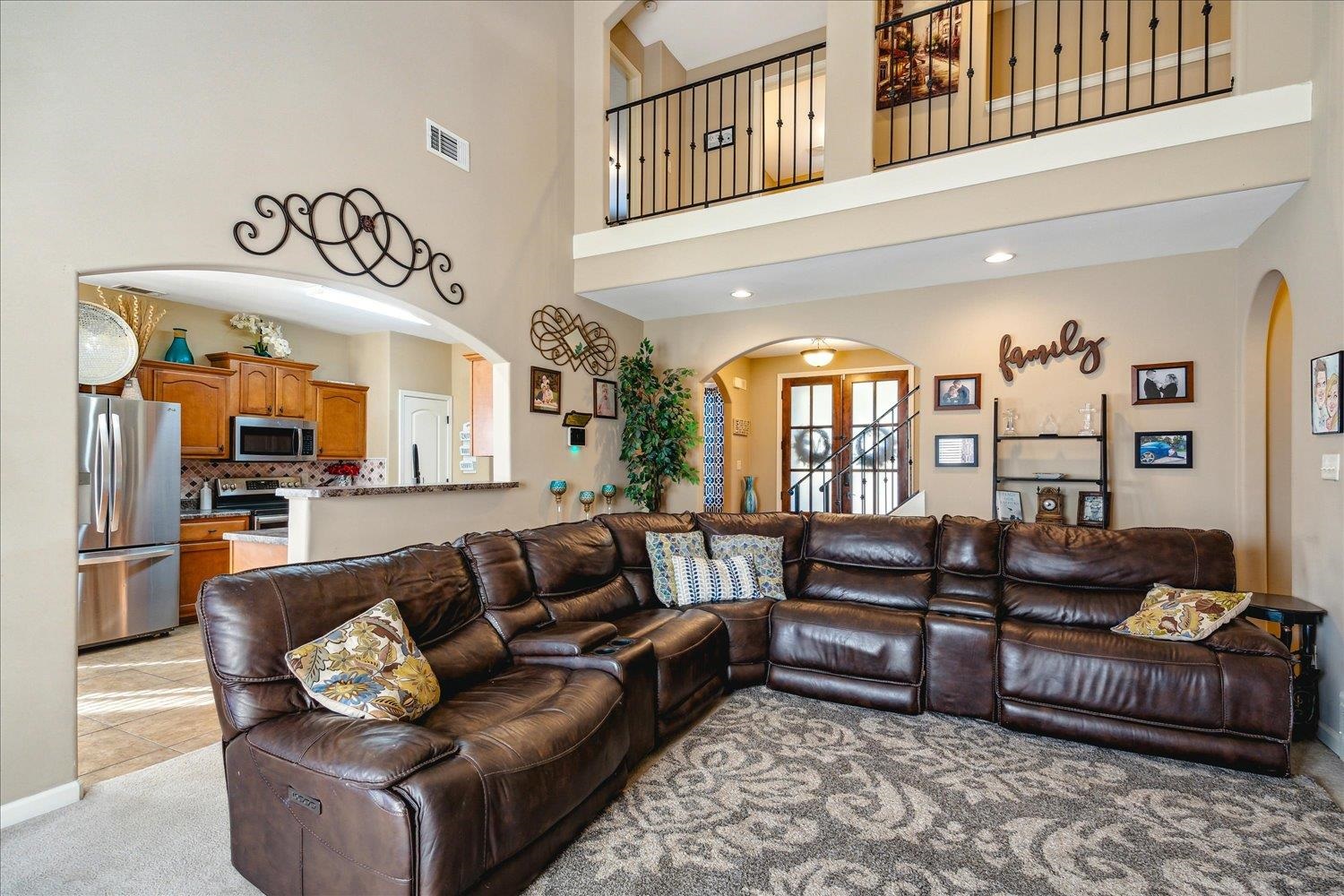 Beautiful Wrought Iron Railing on Upstairs hallway overlooking High-Ceilinged Great Room. Plenty of room for Large, Compfy Sofa.