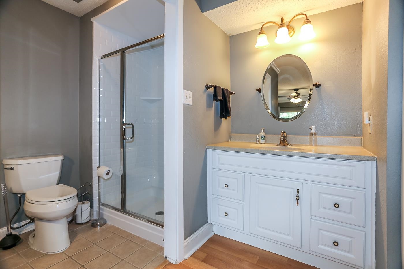 Bathroom with walk in shower, wood-type flooring, and a textured ceiling