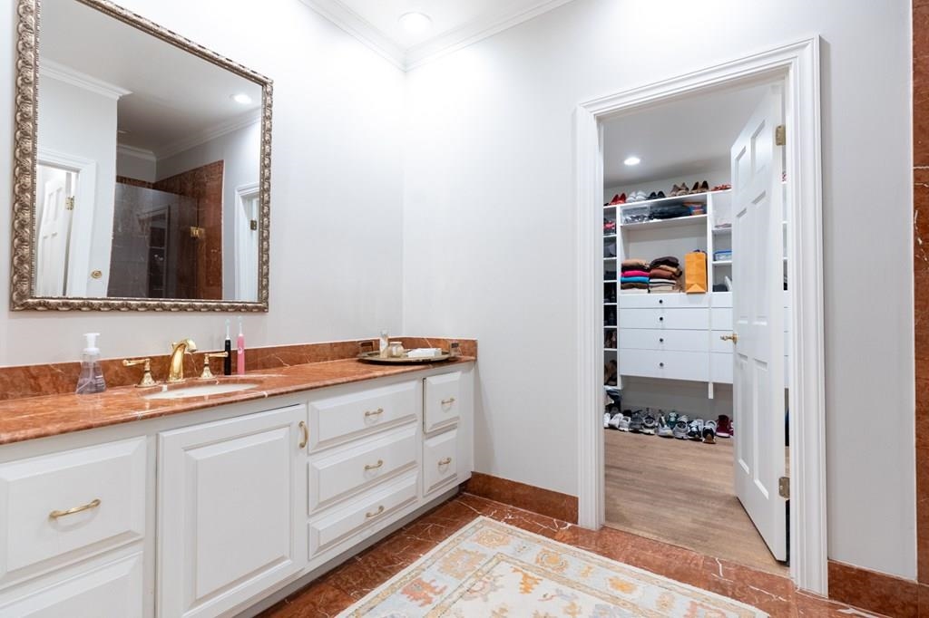 Bathroom featuring vanity, hardwood / wood-style flooring, crown molding, and a shower with shower door