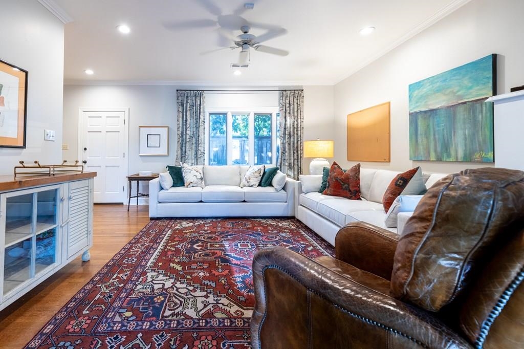 Living room with ceiling fan, hardwood / wood-style flooring, and ornamental molding