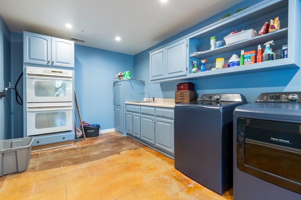 Washroom with washing machine and dryer and sink