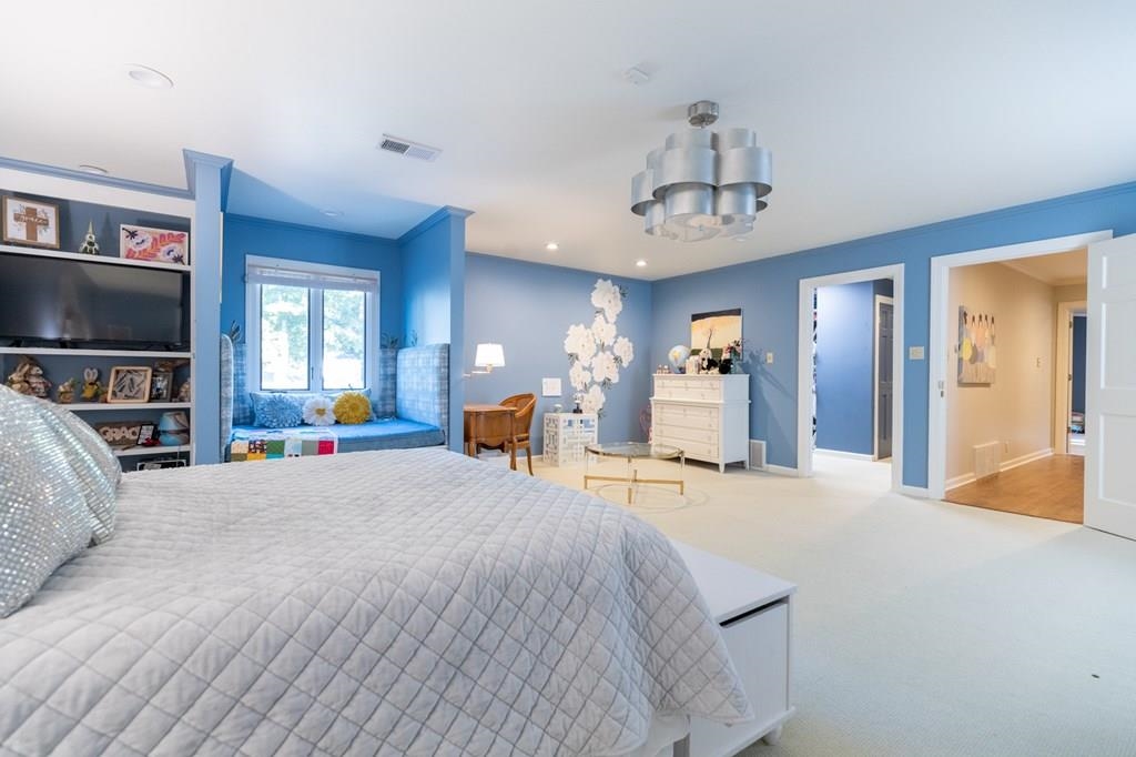 Carpeted bedroom featuring crown molding