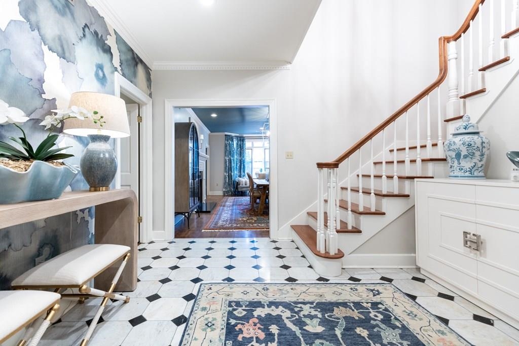 Foyer with ornamental molding and light hardwood / wood-style floors