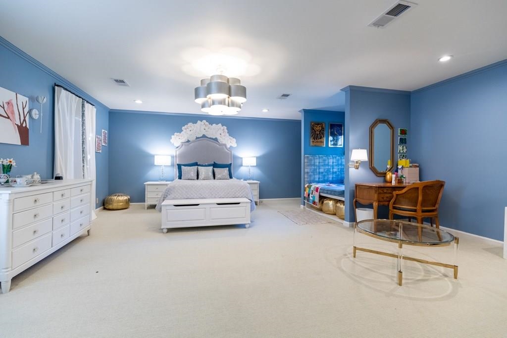 Bedroom featuring a notable chandelier, light carpet, and crown molding