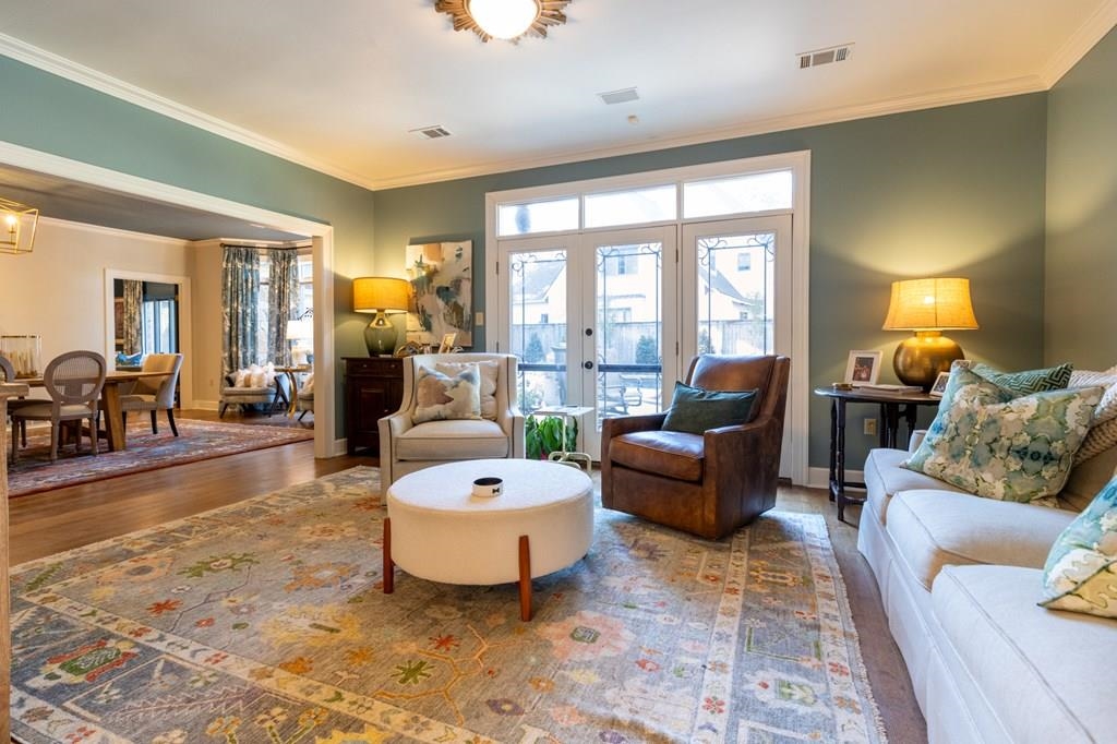 Living room with french doors, dark hardwood / wood-style flooring, and ornamental molding