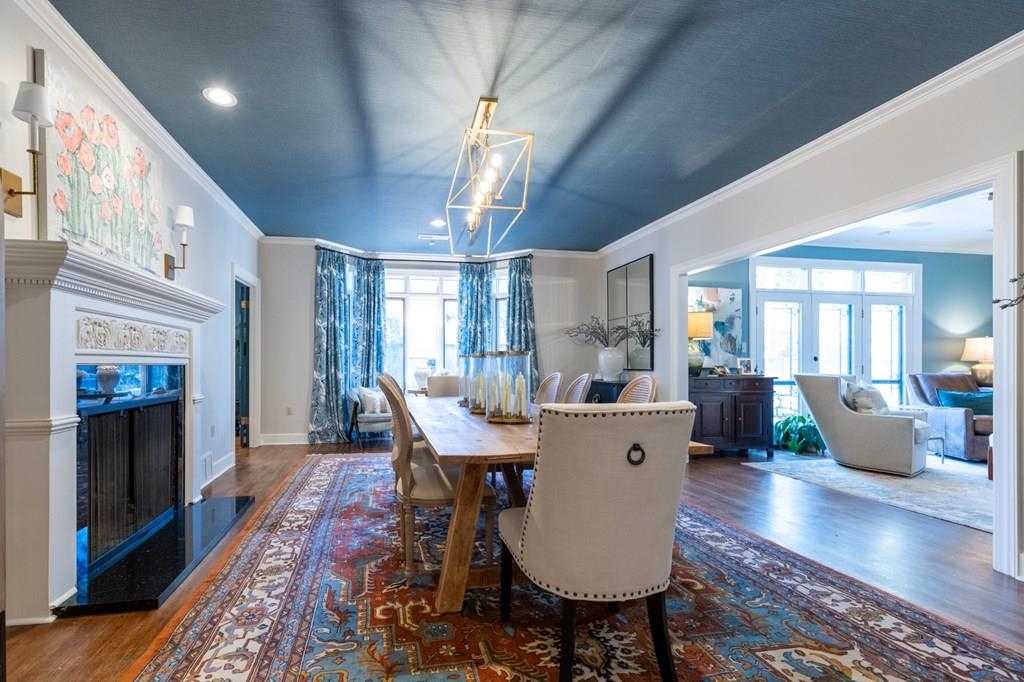 Dining room with a wealth of natural light, a chandelier, crown molding, and dark hardwood / wood-style flooring