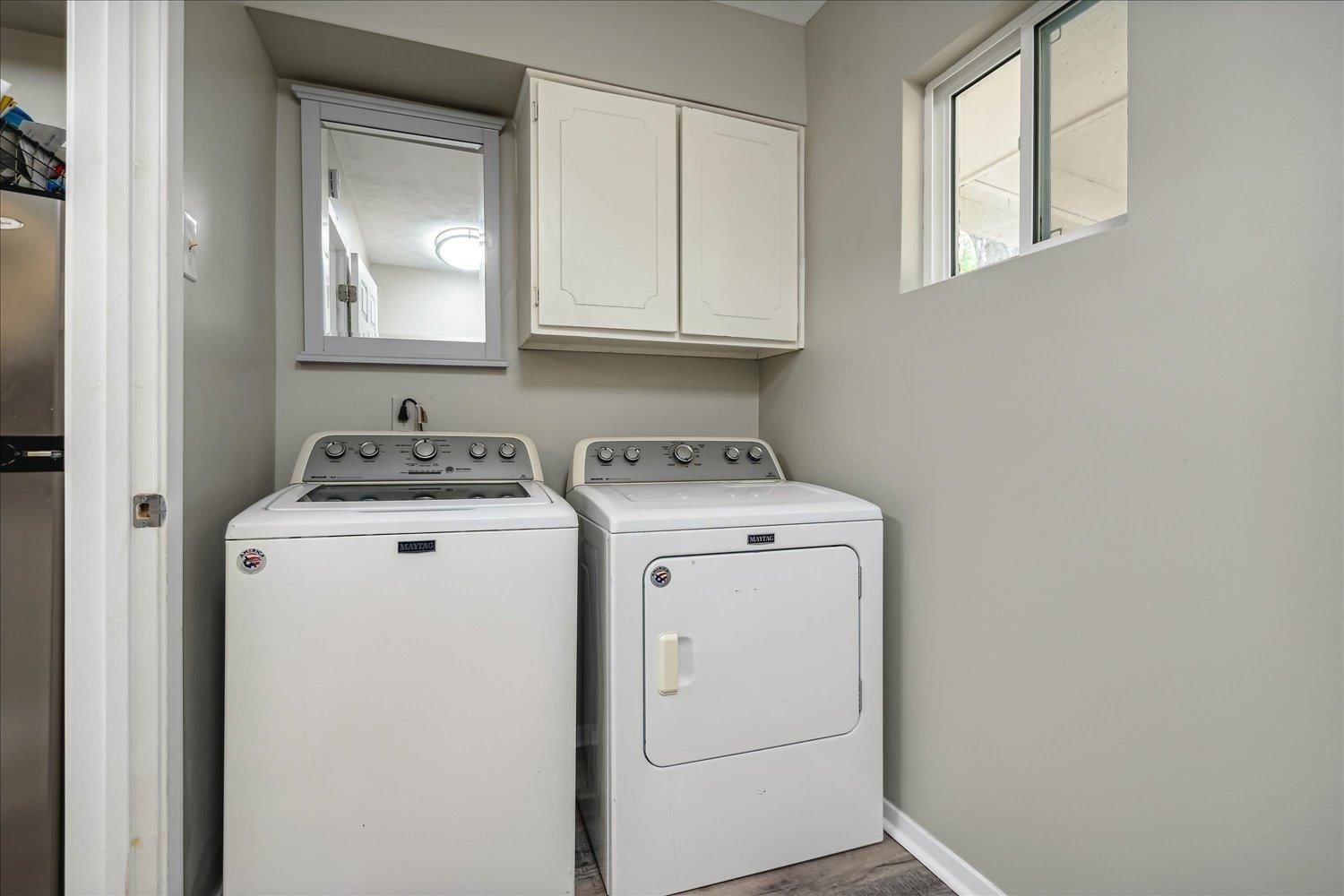 Laundry room featuring washing machine and dryer, cabinets, and hardwood / wood-style flooring