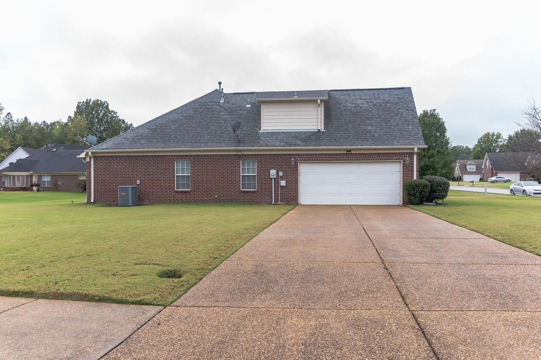 Exterior space featuring central AC unit, a lawn, and a garage