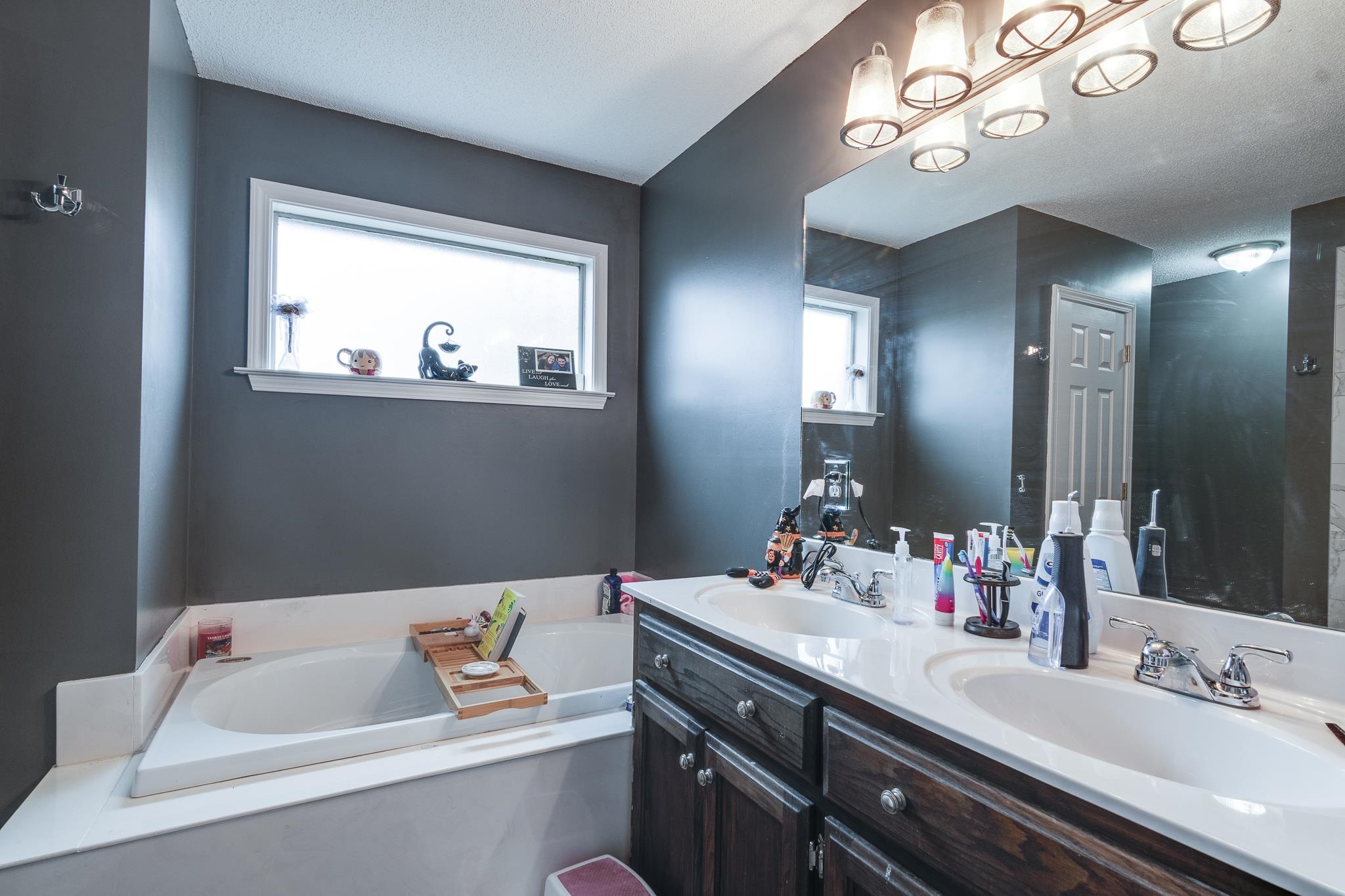 Bathroom with a washtub, vanity, and a textured ceiling