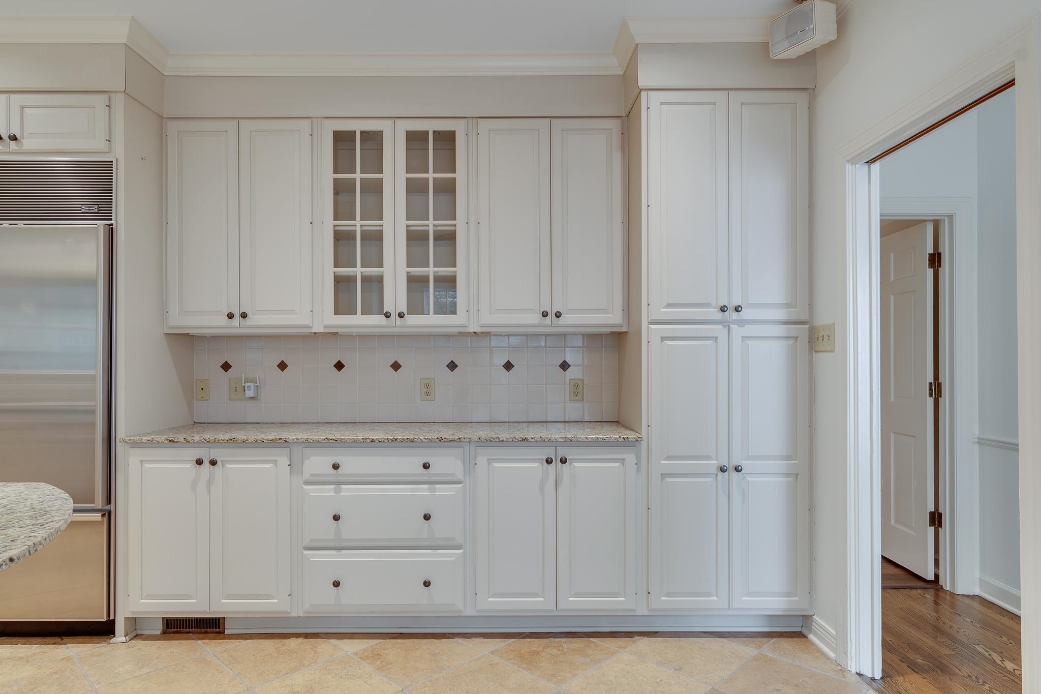 Kitchen featuring white cabinetry, decorative backsplash, and built in fridge