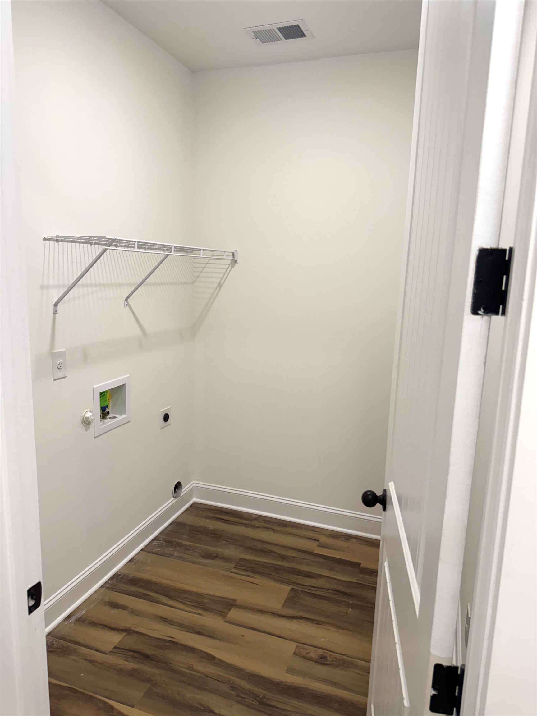 Washroom with hookup for a washing machine, dark wood-type flooring, and electric dryer hookup