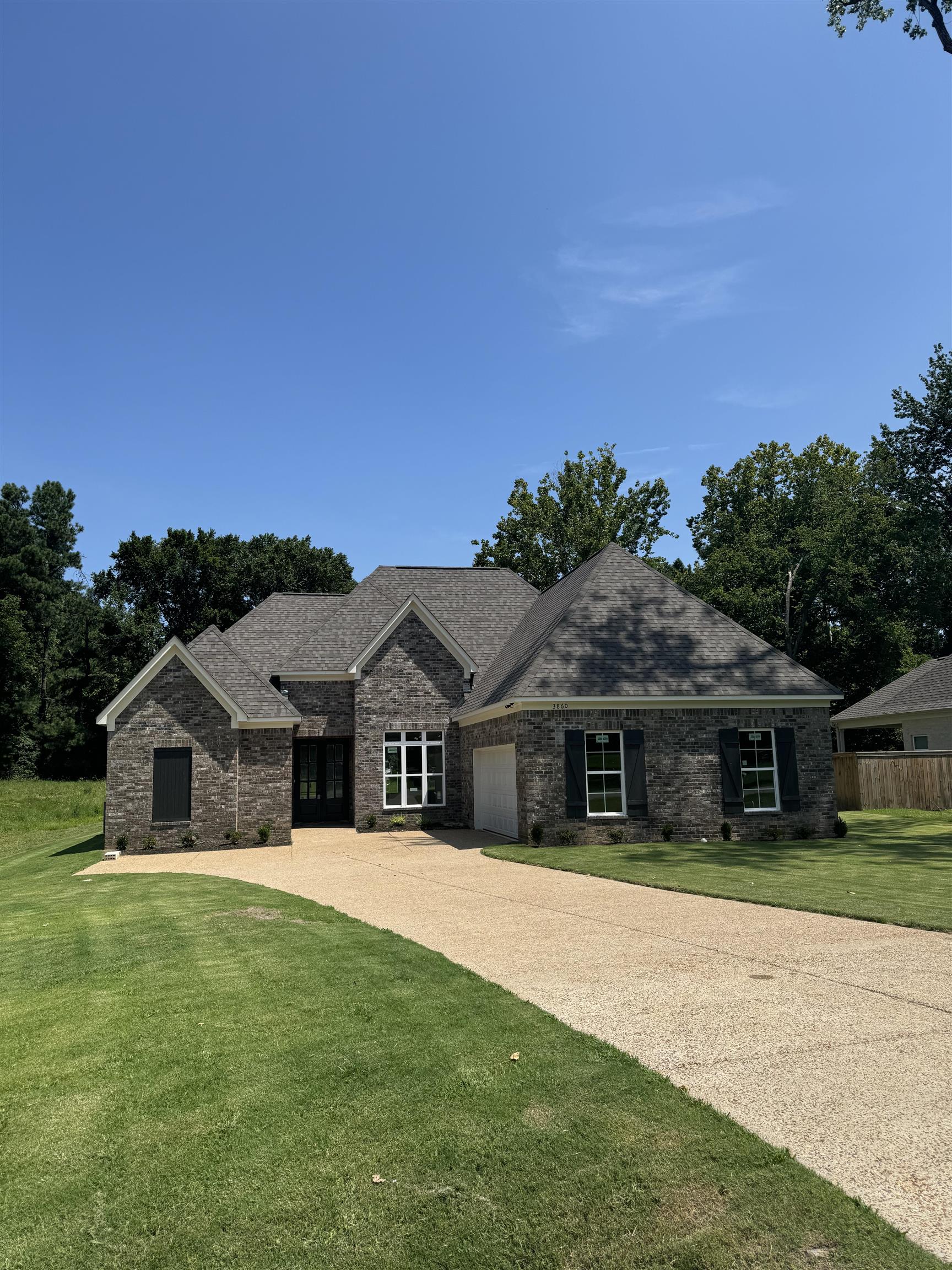 View of front of home with a garage and a front lawn