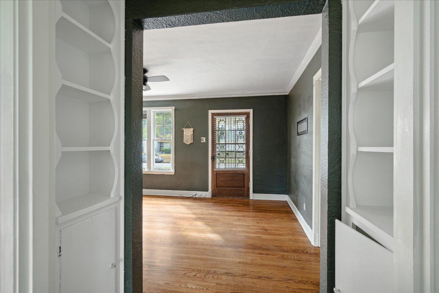 Entryway featuring hardwood / wood-style flooring, ceiling fan, and crown molding