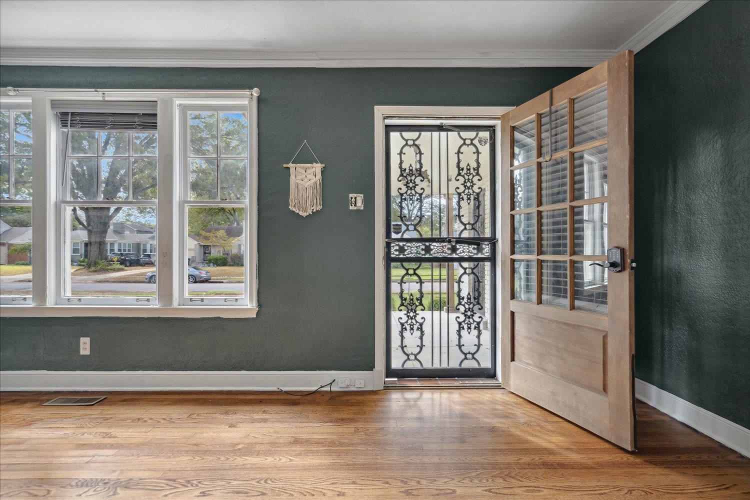 Entryway with wood-type flooring and crown molding