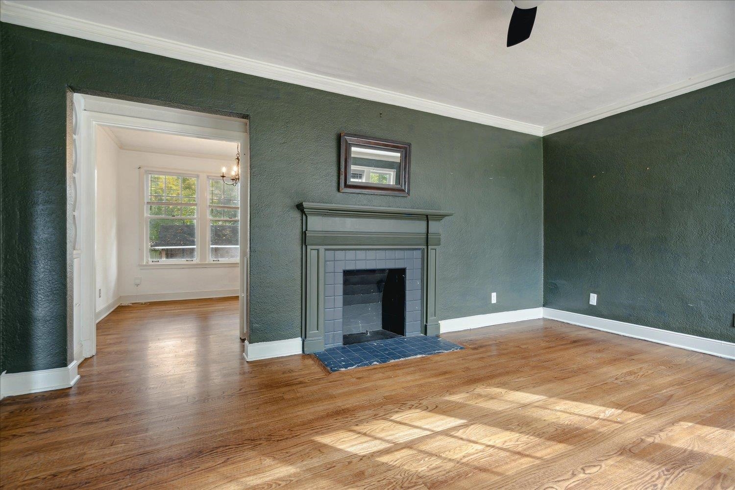 Unfurnished living room featuring ornamental molding, a fireplace, and hardwood / wood-style flooring