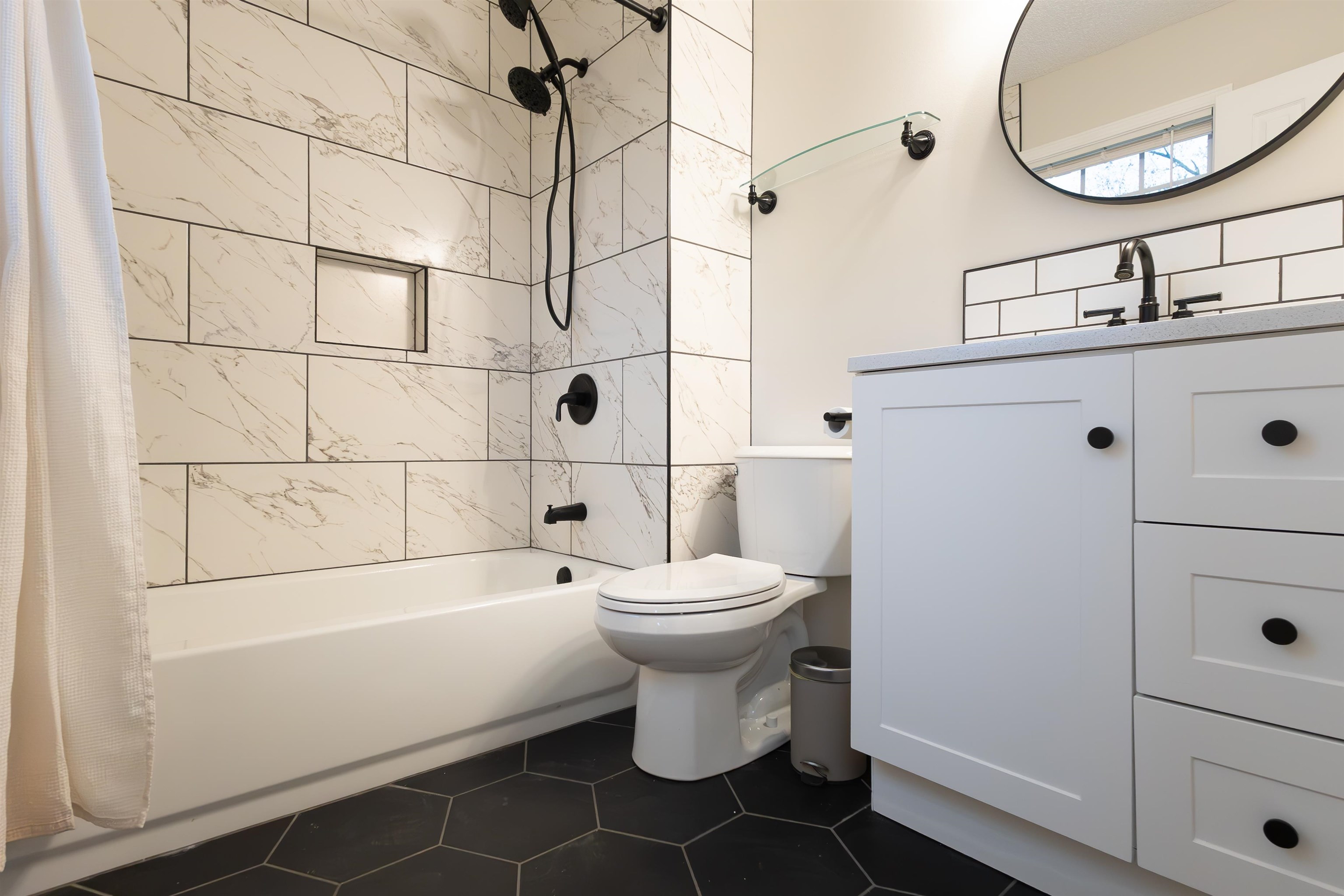 Full bathroom featuring shower / tub combo with curtain, vanity, toilet, and tile patterned floors