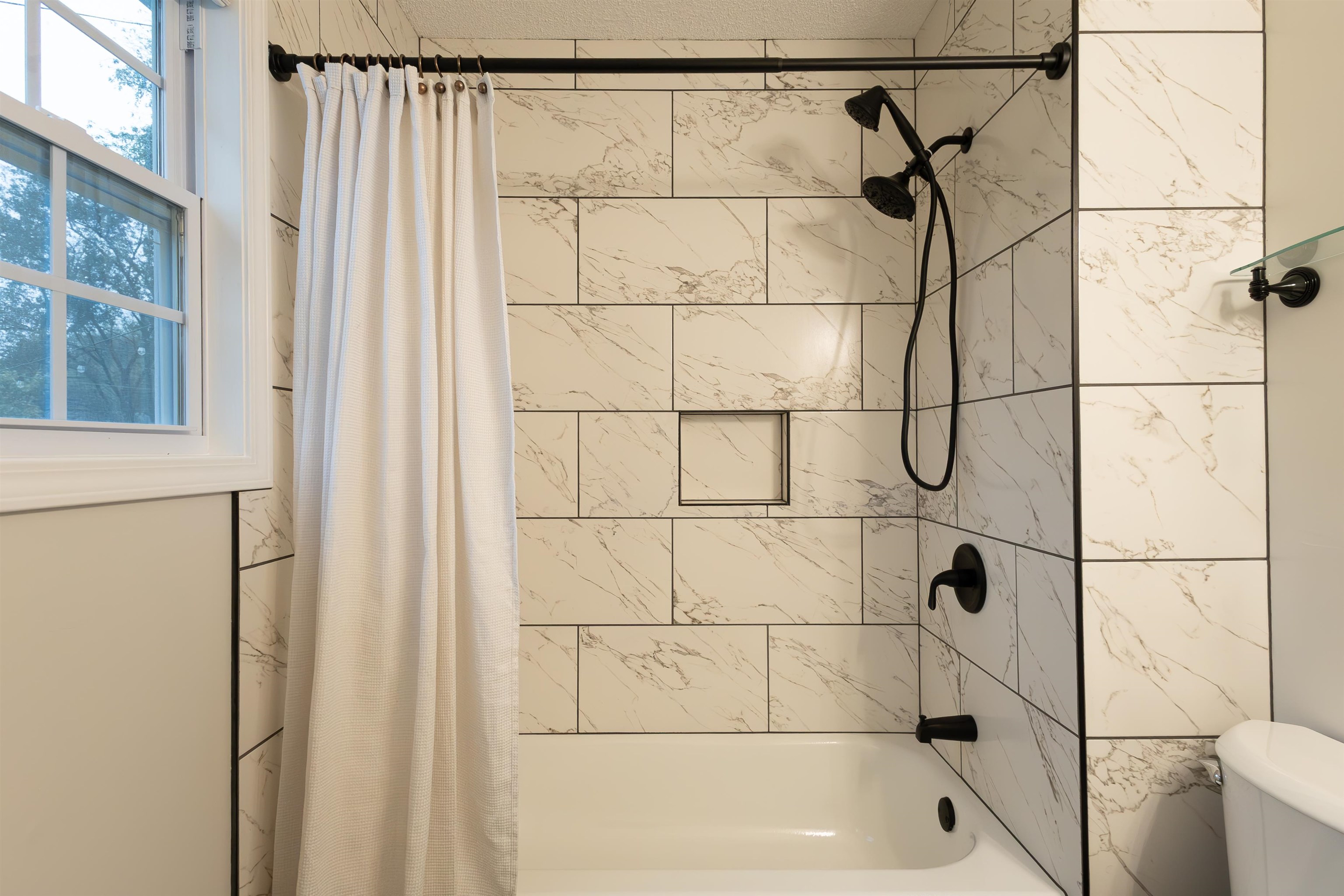 Bathroom featuring shower / tub combo with curtain and toilet