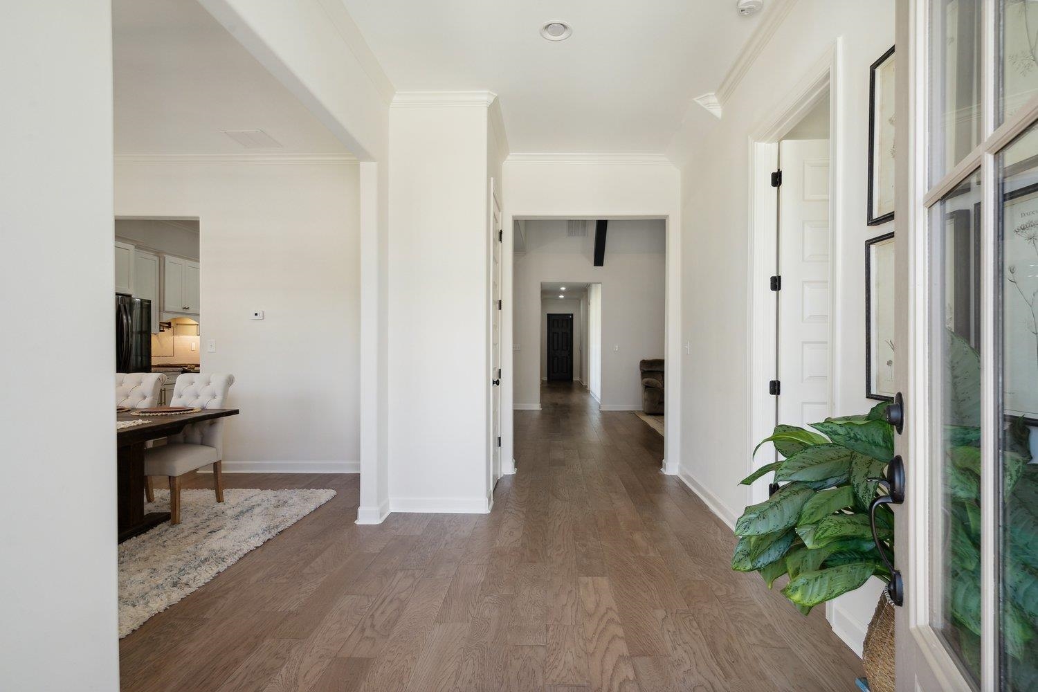 Welcome Home, this beautiful 2 story entry way allows you to see the beautiful features of this home though out. Featuring custom molding wide-planked engineered hardwood, an upgraded feature to this build in \'22 and the high spacious ceilings.