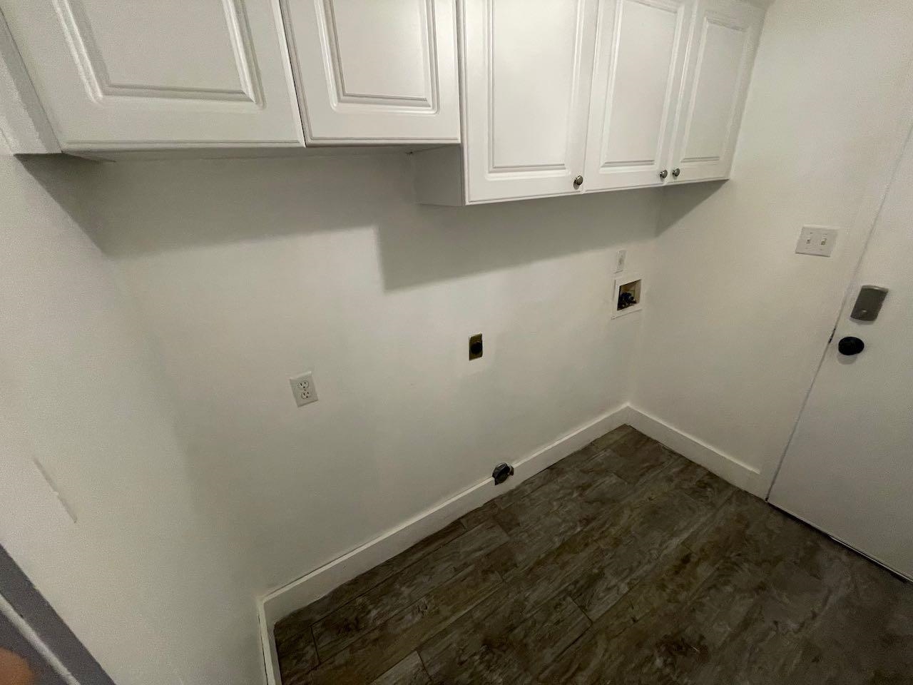 Washroom with hookup for an electric dryer, dark hardwood / wood-style floors, washer hookup, and cabinets