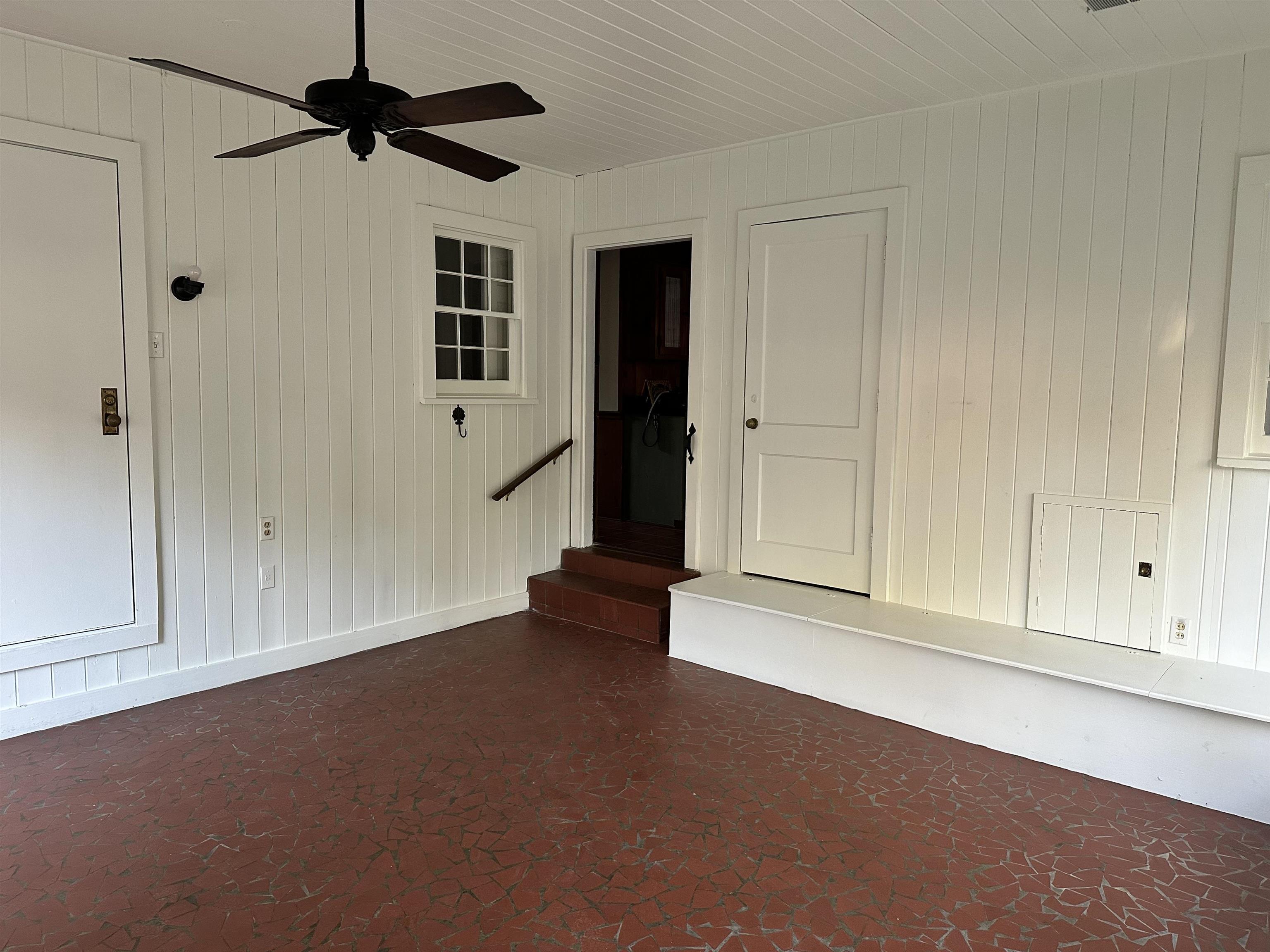 Empty room with wood walls and ceiling fan