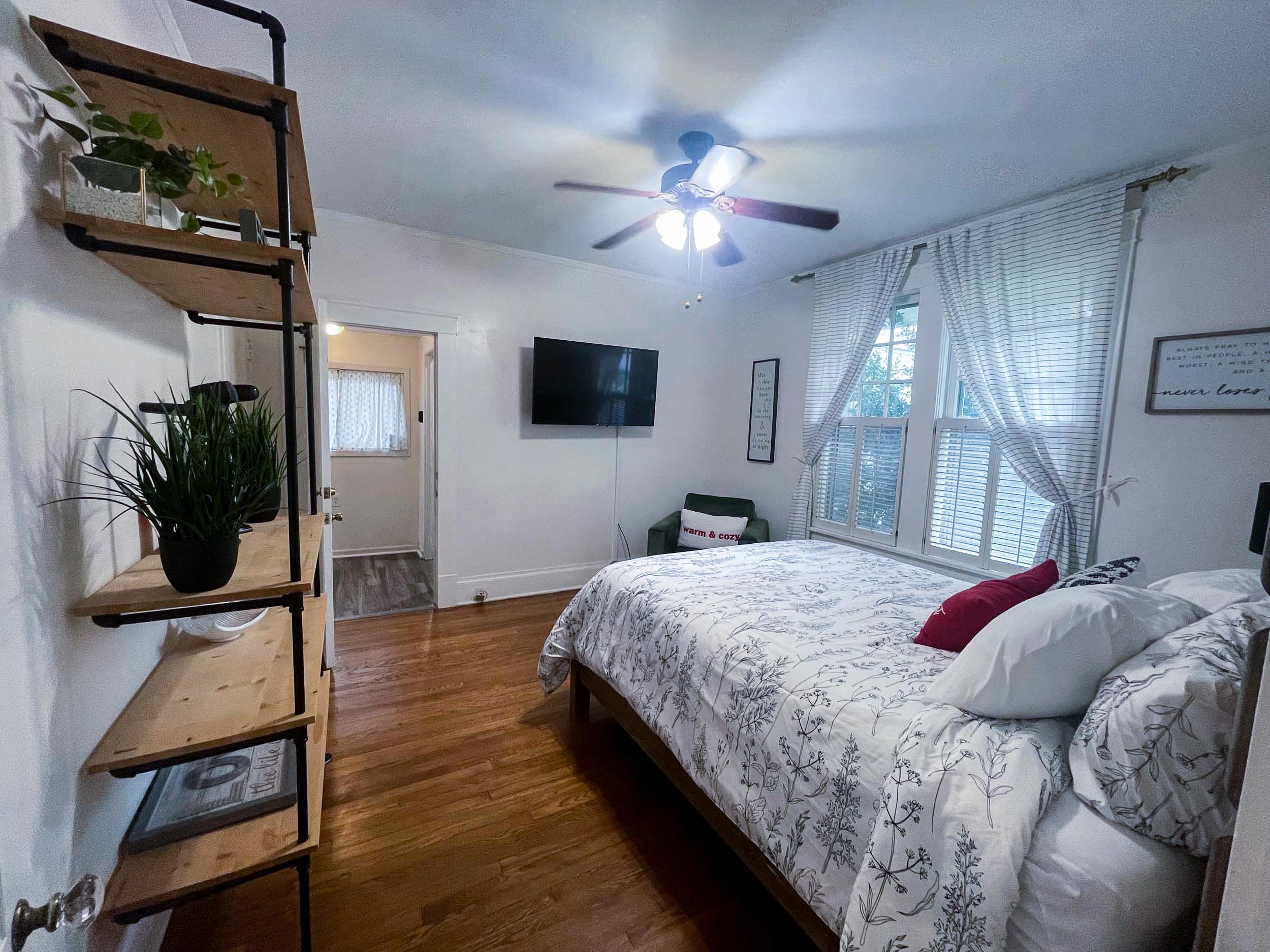 Bedroom featuring ceiling fan, multiple windows, and dark hardwood / wood-style floors