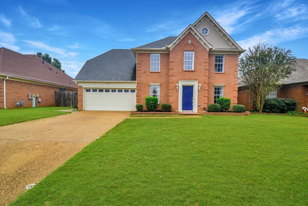 View of front of house featuring a garage and a front yard