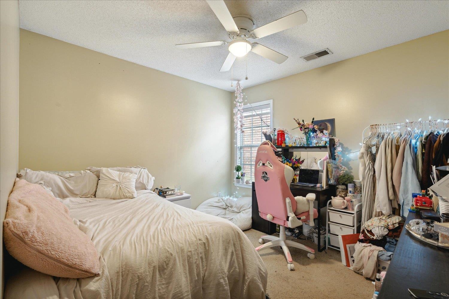 Bedroom featuring a textured ceiling, carpet floors, and ceiling fan