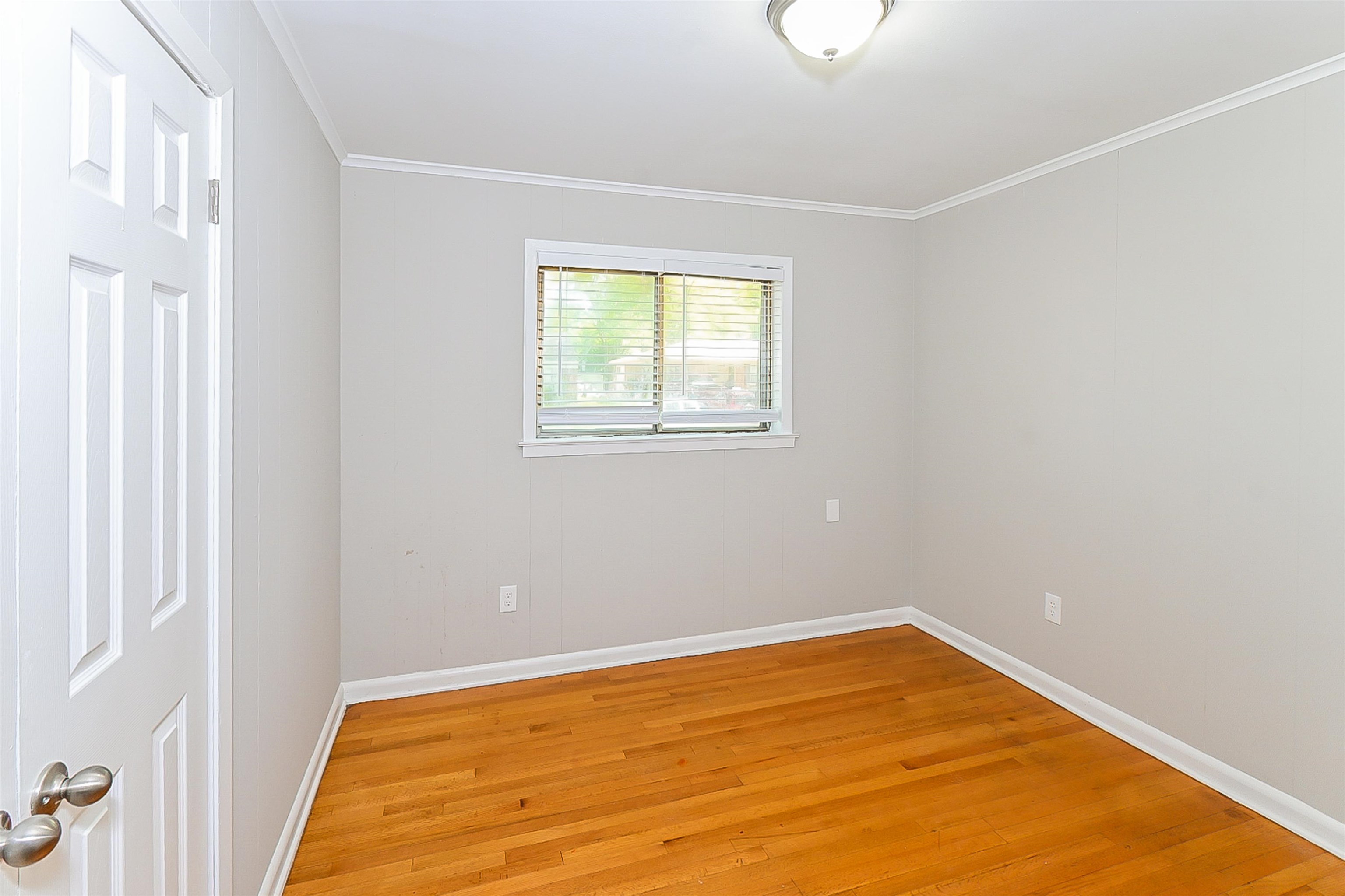 Spare room featuring ornamental molding and hardwood / wood-style flooring