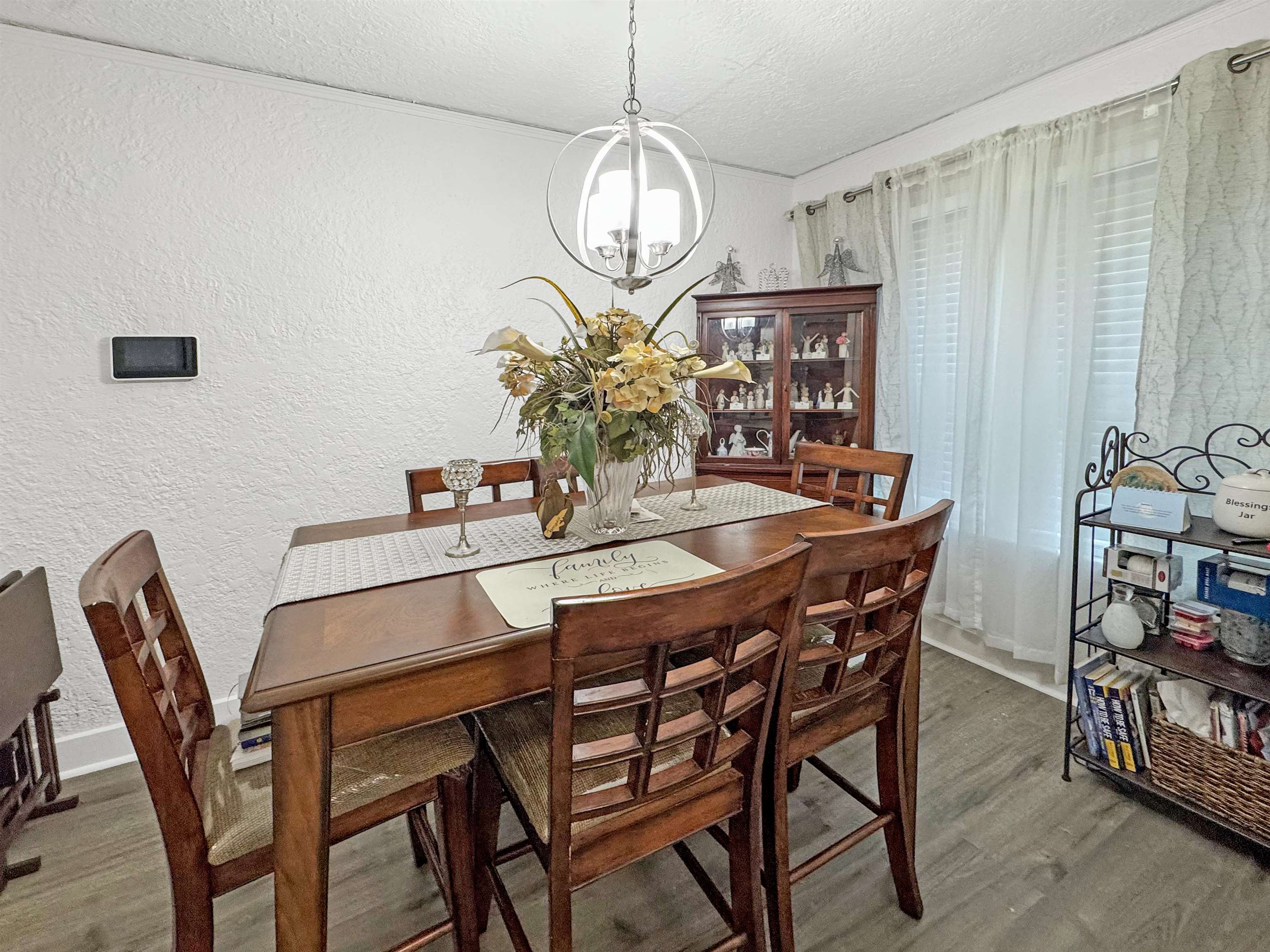 Dining space with hardwood / wood-style flooring, a chandelier, and a textured ceiling