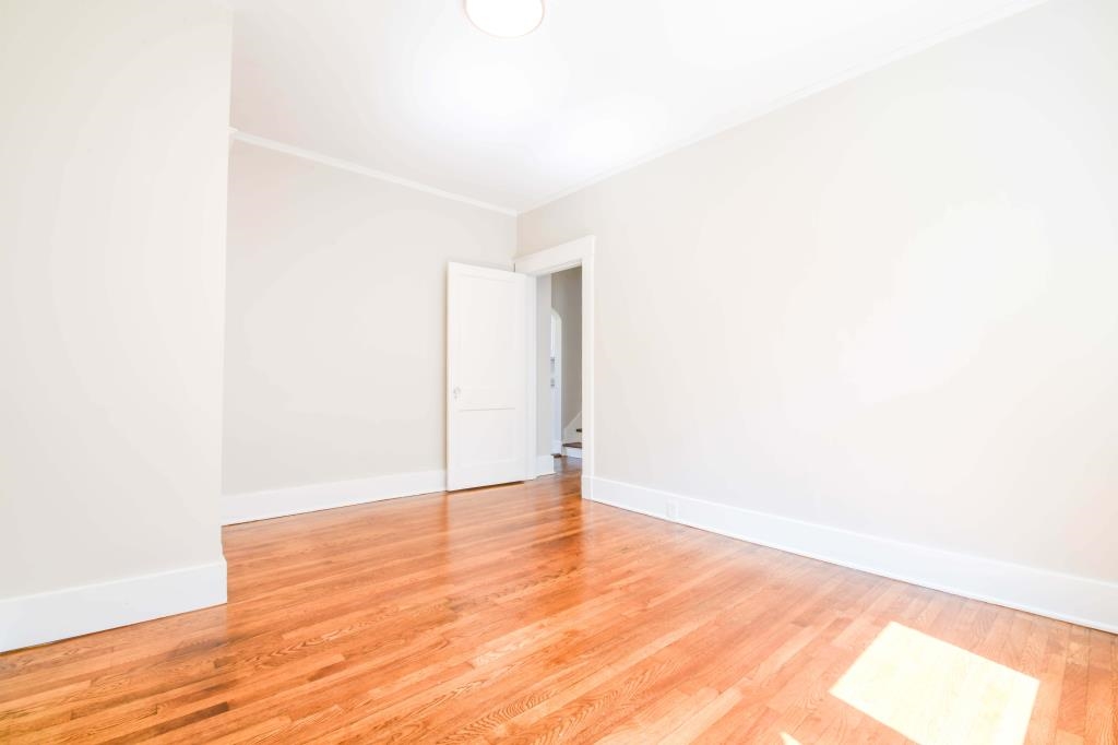 Empty room featuring hardwood / wood-style flooring and crown molding