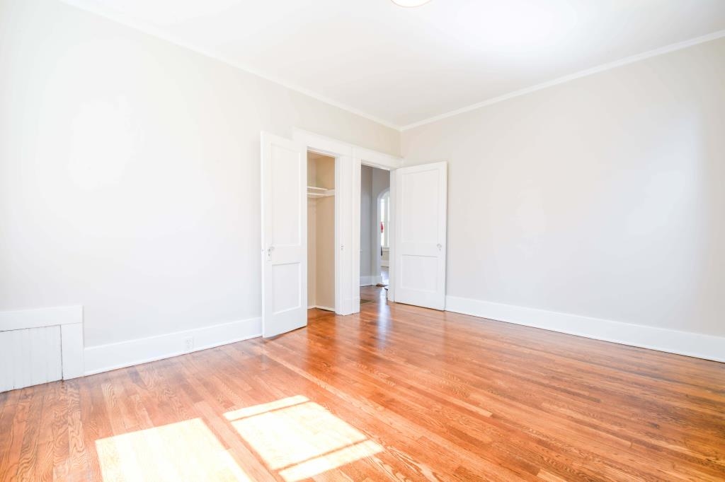 Unfurnished room featuring wood-type flooring and ornamental molding