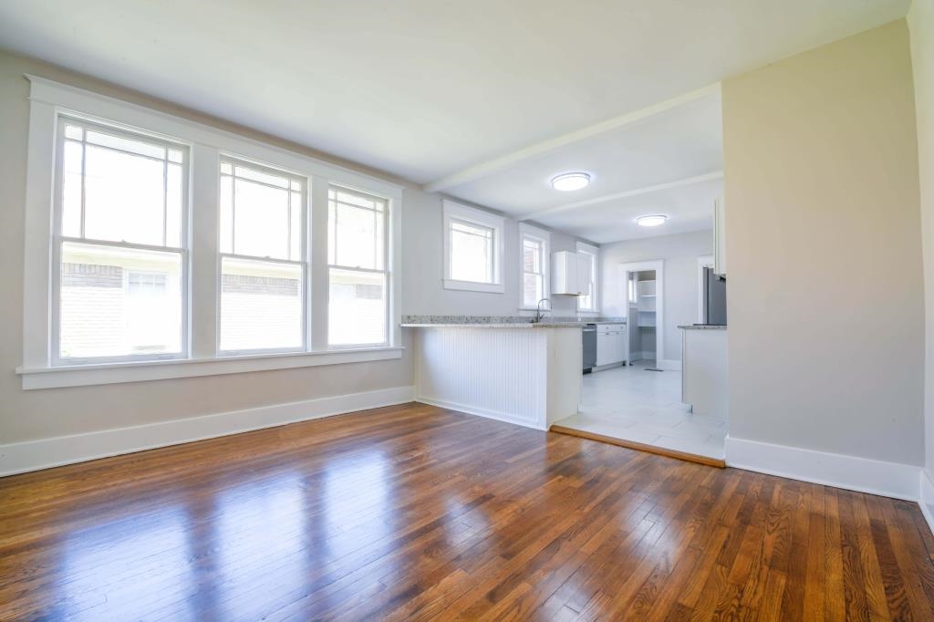 Unfurnished living room with dark wood-type flooring