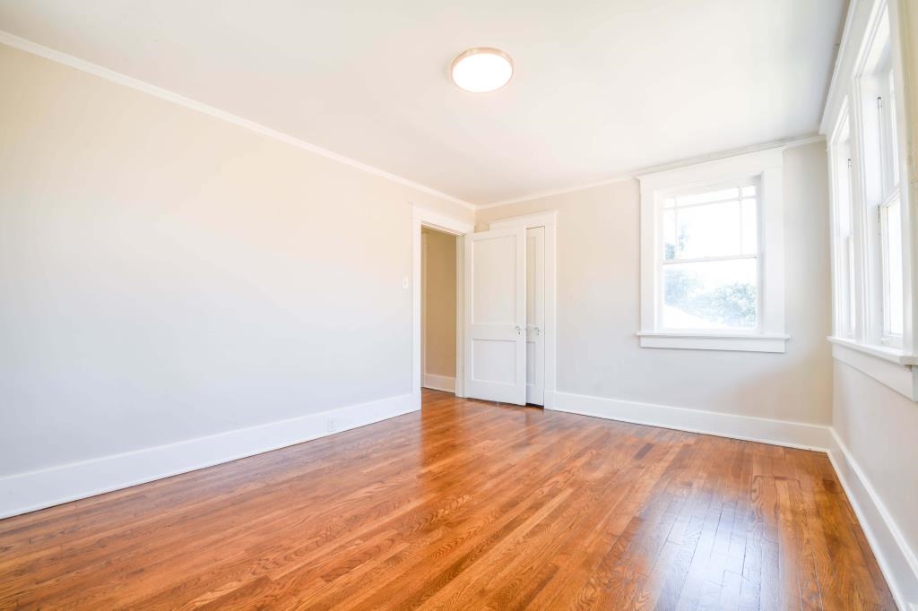 Spare room with hardwood / wood-style floors and crown molding