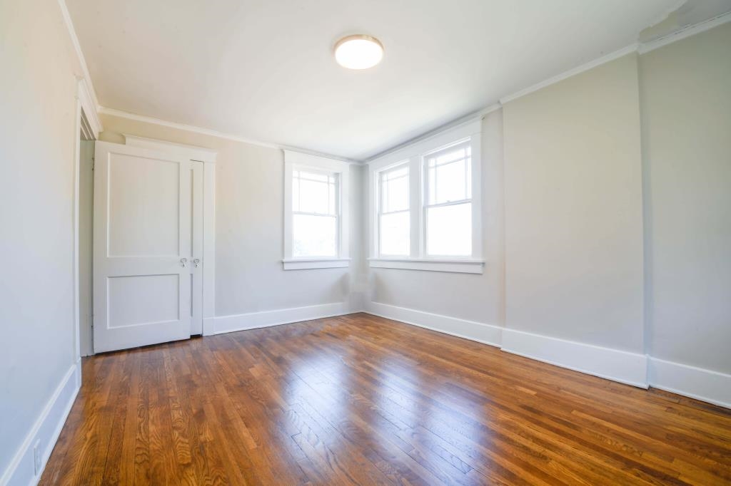 Unfurnished room with ornamental molding and dark hardwood / wood-style floors