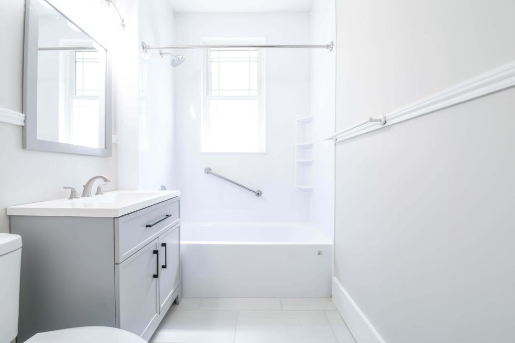 Full bathroom with tile patterned floors, vanity, toilet, and shower / washtub combination