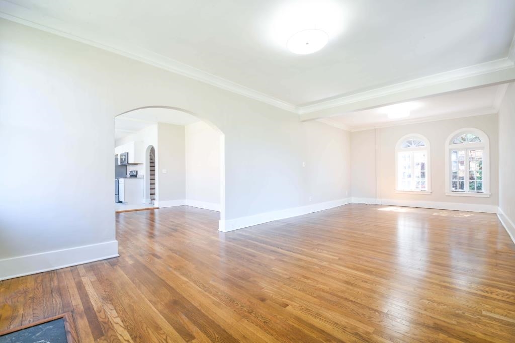 Unfurnished room with hardwood / wood-style flooring and crown molding