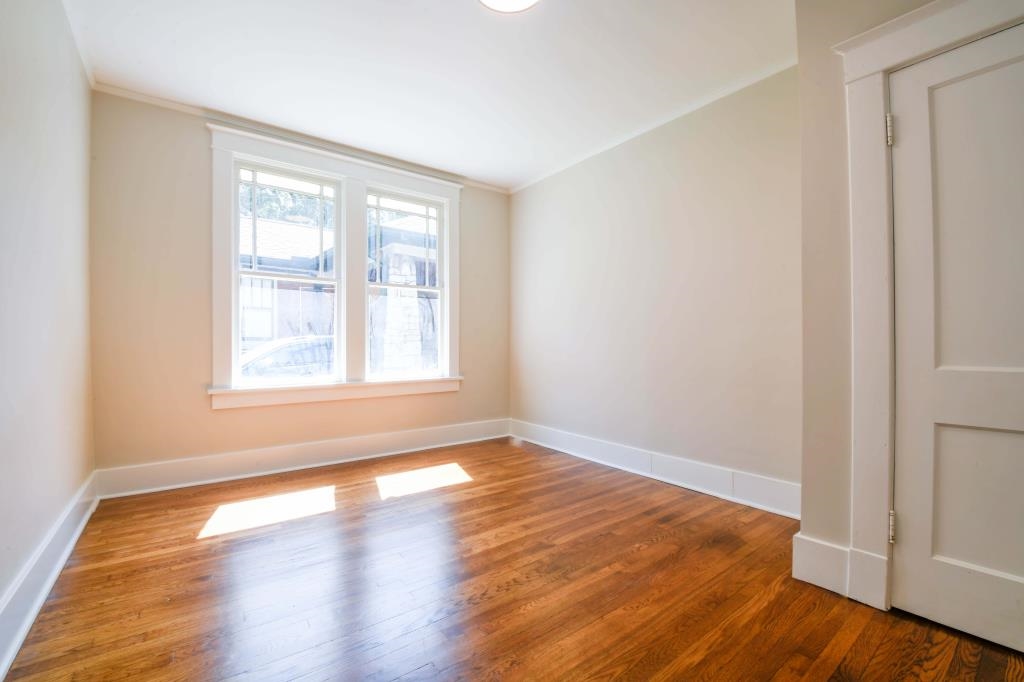 Empty room featuring hardwood / wood-style floors and crown molding