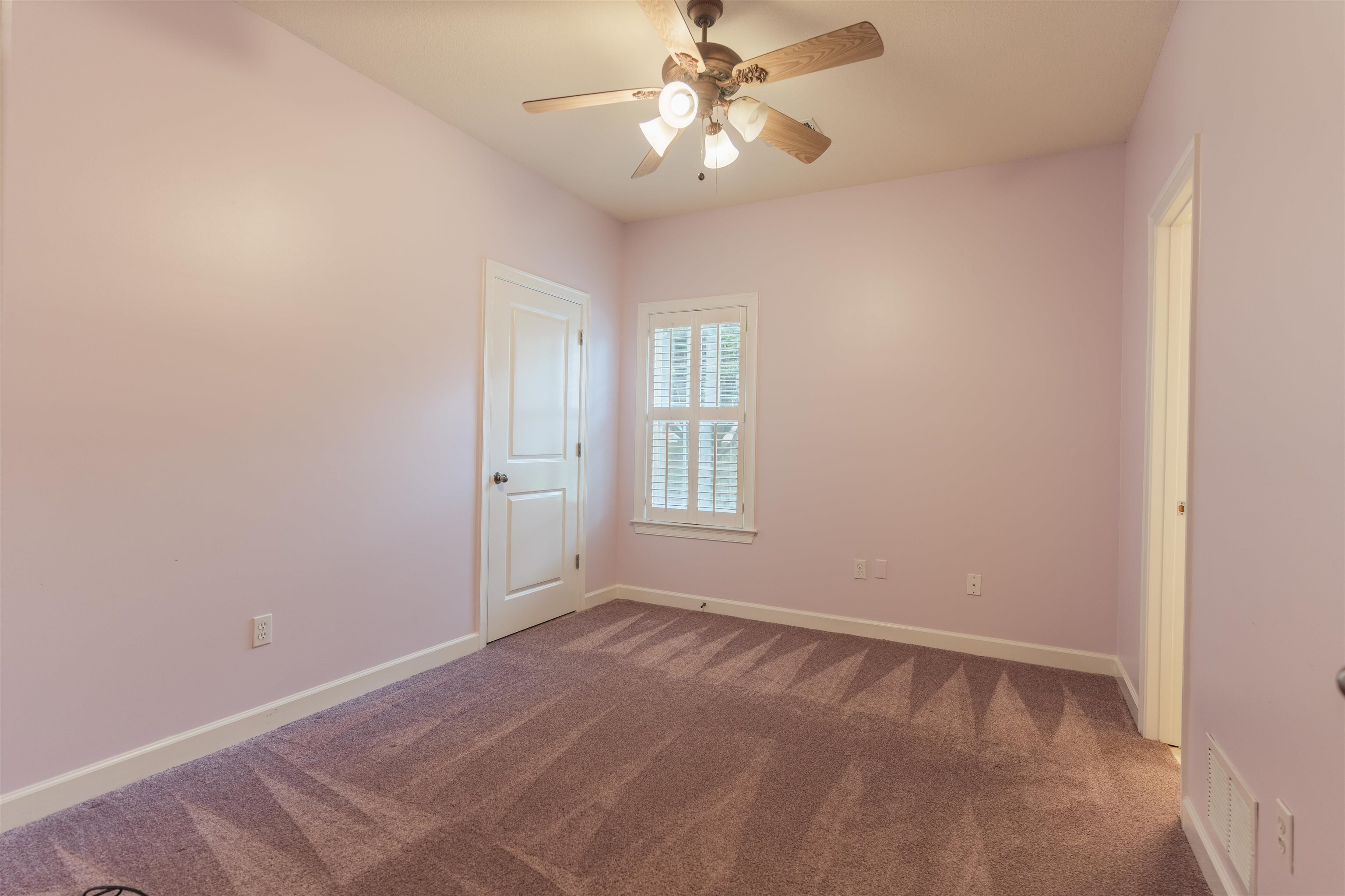 Empty room with ceiling fan and carpet floors