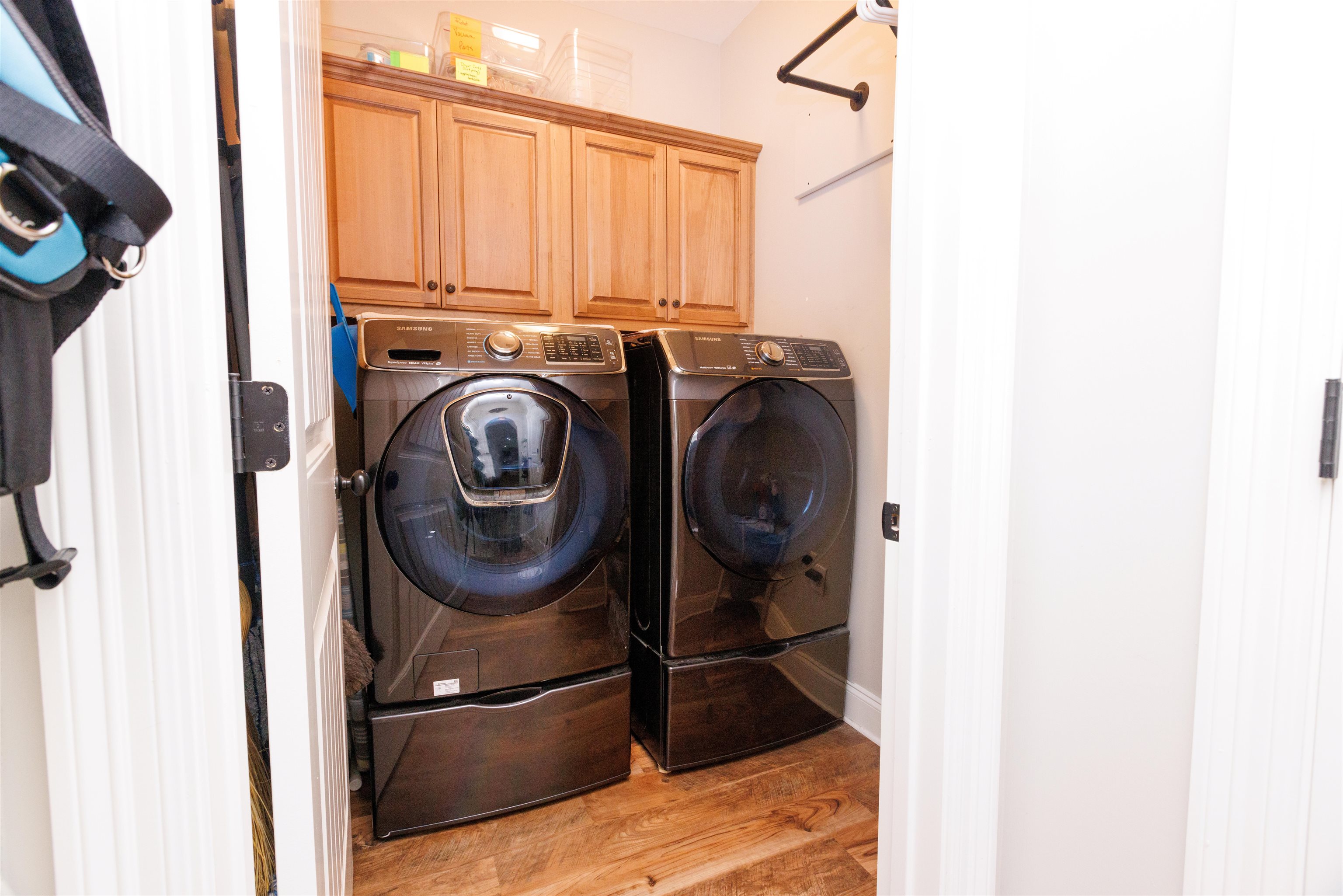 Laundry room featuring light hardwood / wood-style floors, washing machine and dryer, and cabinets