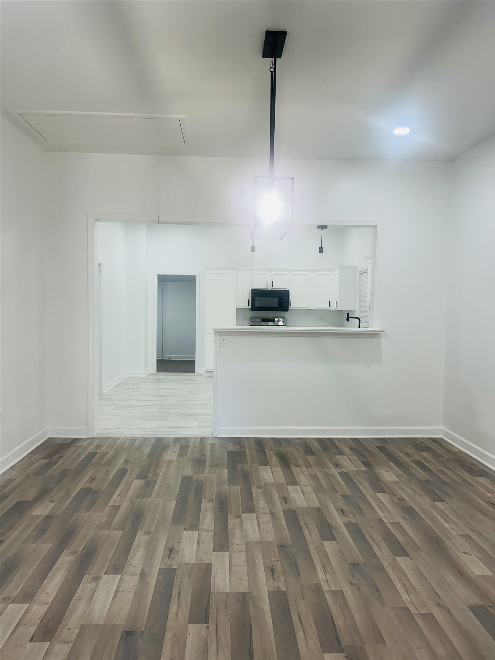 Kitchen featuring white cabinets, hardwood / wood-style floors, and kitchen peninsula