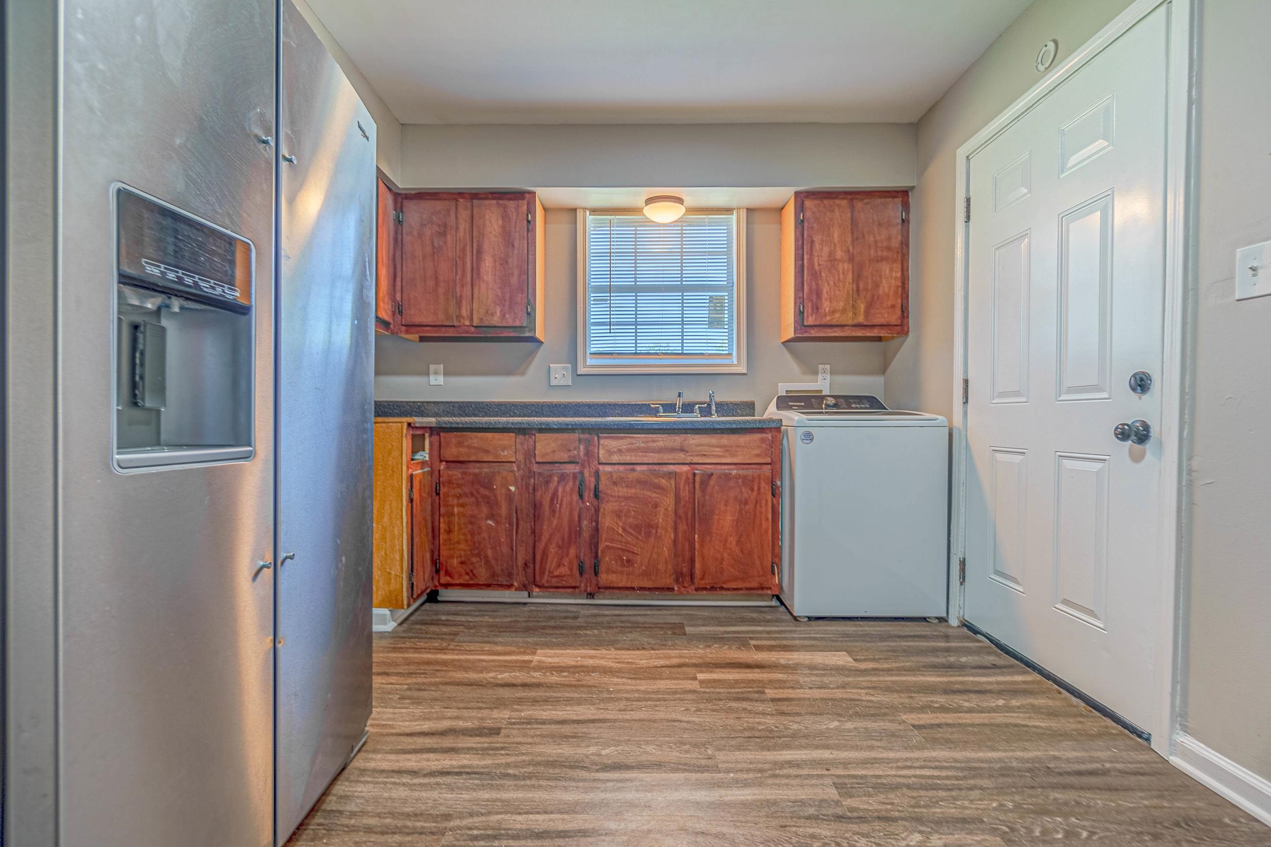 Laundry area featuring cabinets, sink, hardwood / wood-style flooring, and washer / dryer