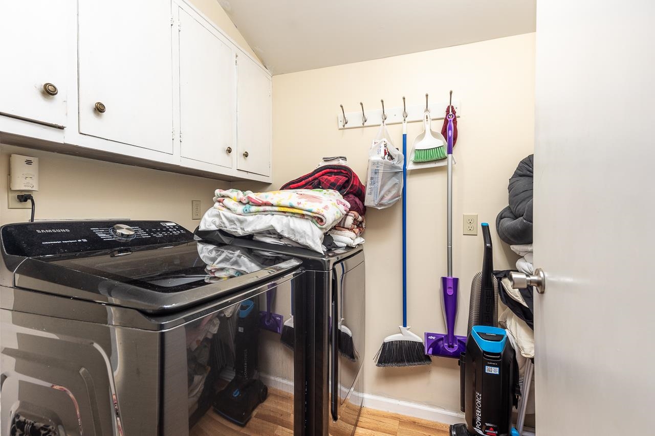 Laundry room featuring light wood-type flooring, cabinets, and washing machine and clothes dryer