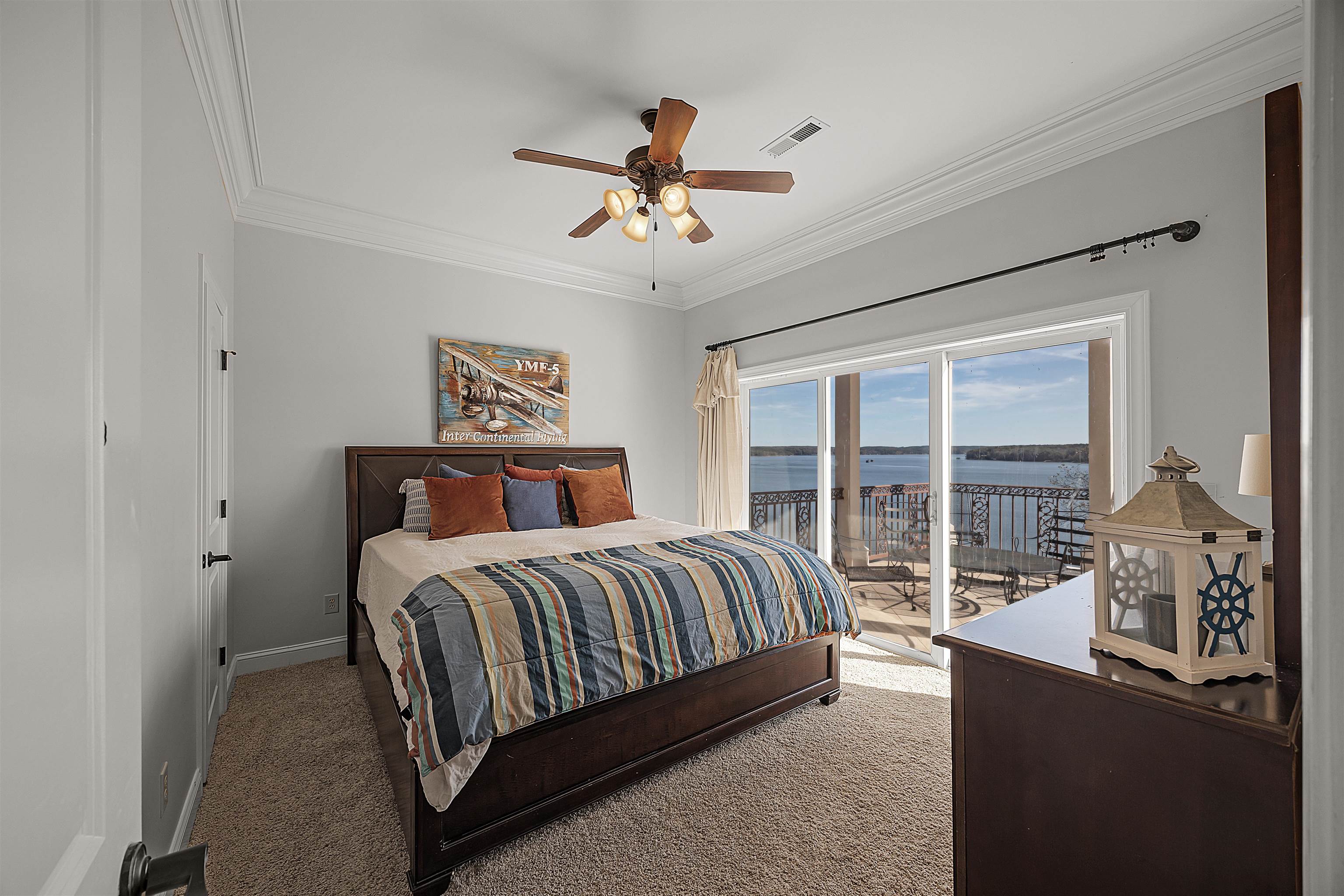 Bedroom with a water view, access to exterior, carpet floors, ornamental molding, and ceiling fan