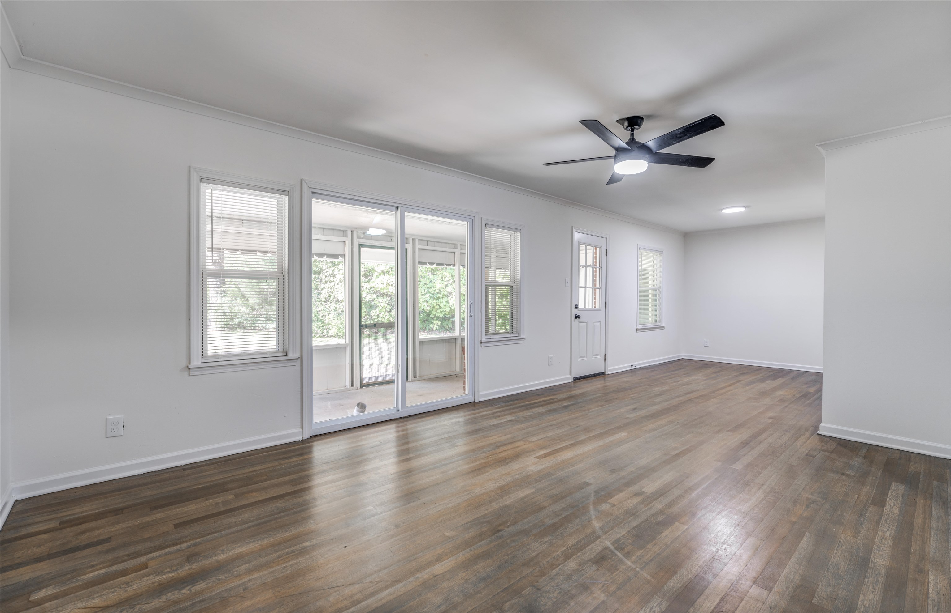 Empty room featuring dark hardwood / wood-style flooring, ceiling fan, and crown molding