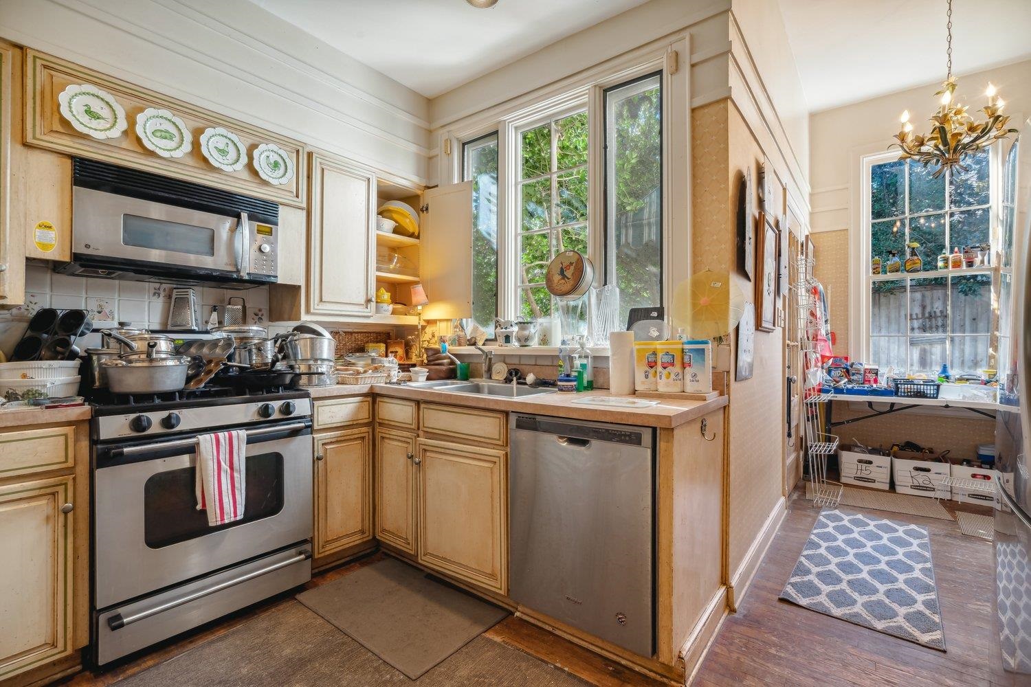 Kitchen featuring stainless steel appliances, decorative light fixtures, dark hardwood / wood-style flooring, sink, and a chandelier