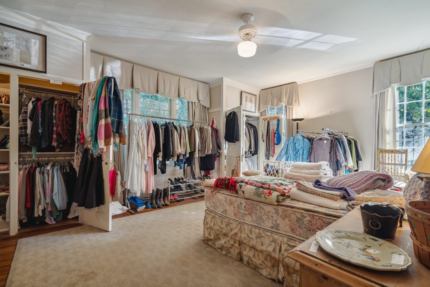 Walk in closet with hardwood / wood-style flooring