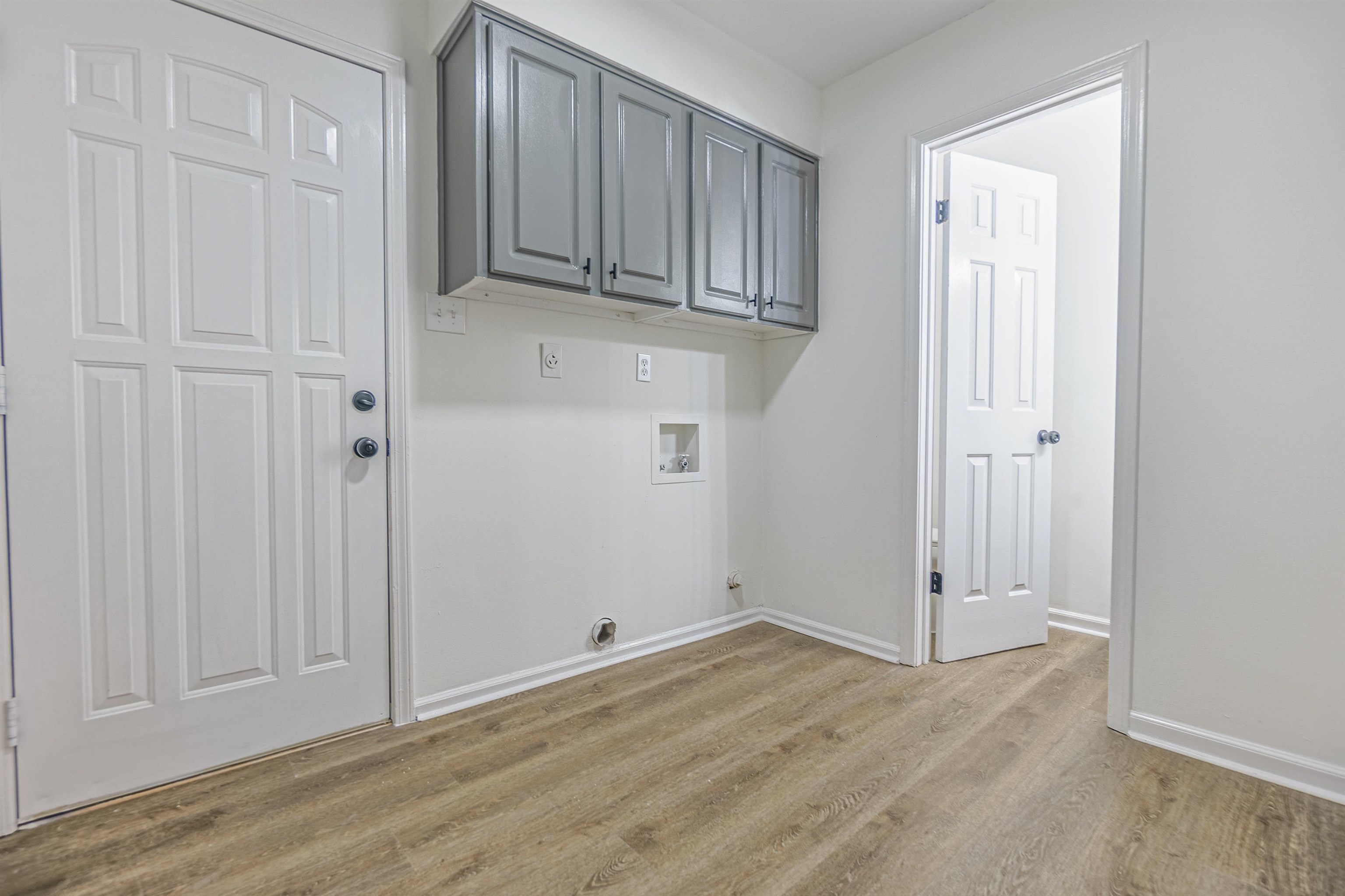 Laundry room with cabinets, hookup for a washing machine, and light wood-type flooring