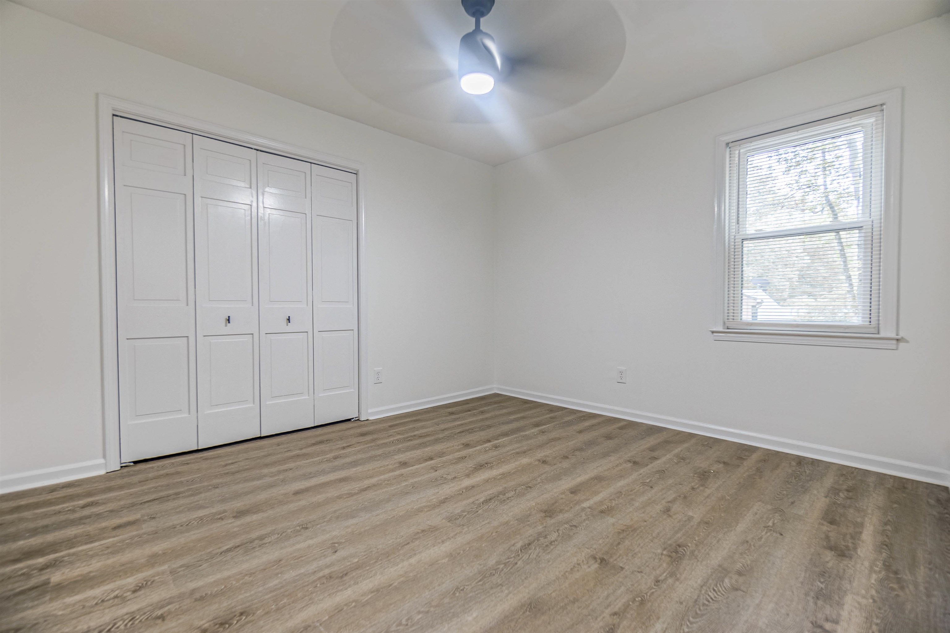 Unfurnished bedroom featuring a closet, light hardwood / wood-style floors, and ceiling fan